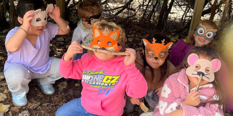 Students wearing homemade animal masks in the school forest